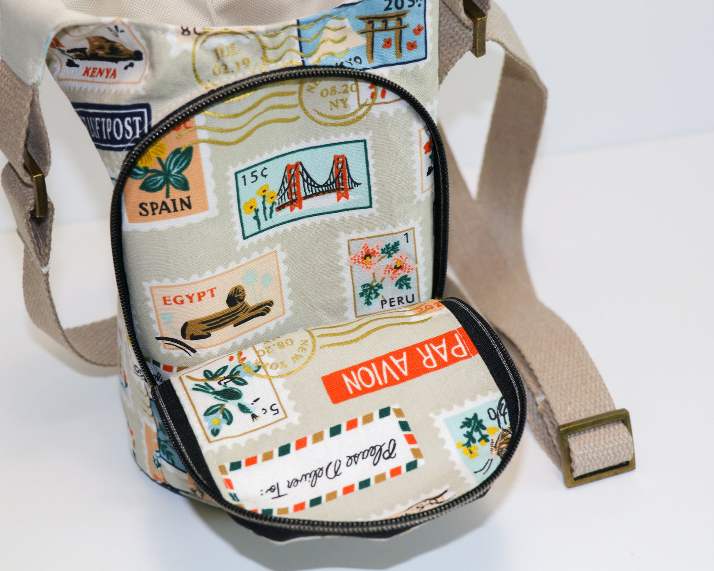 postage stamps print water bottle sling, front view with pocket open