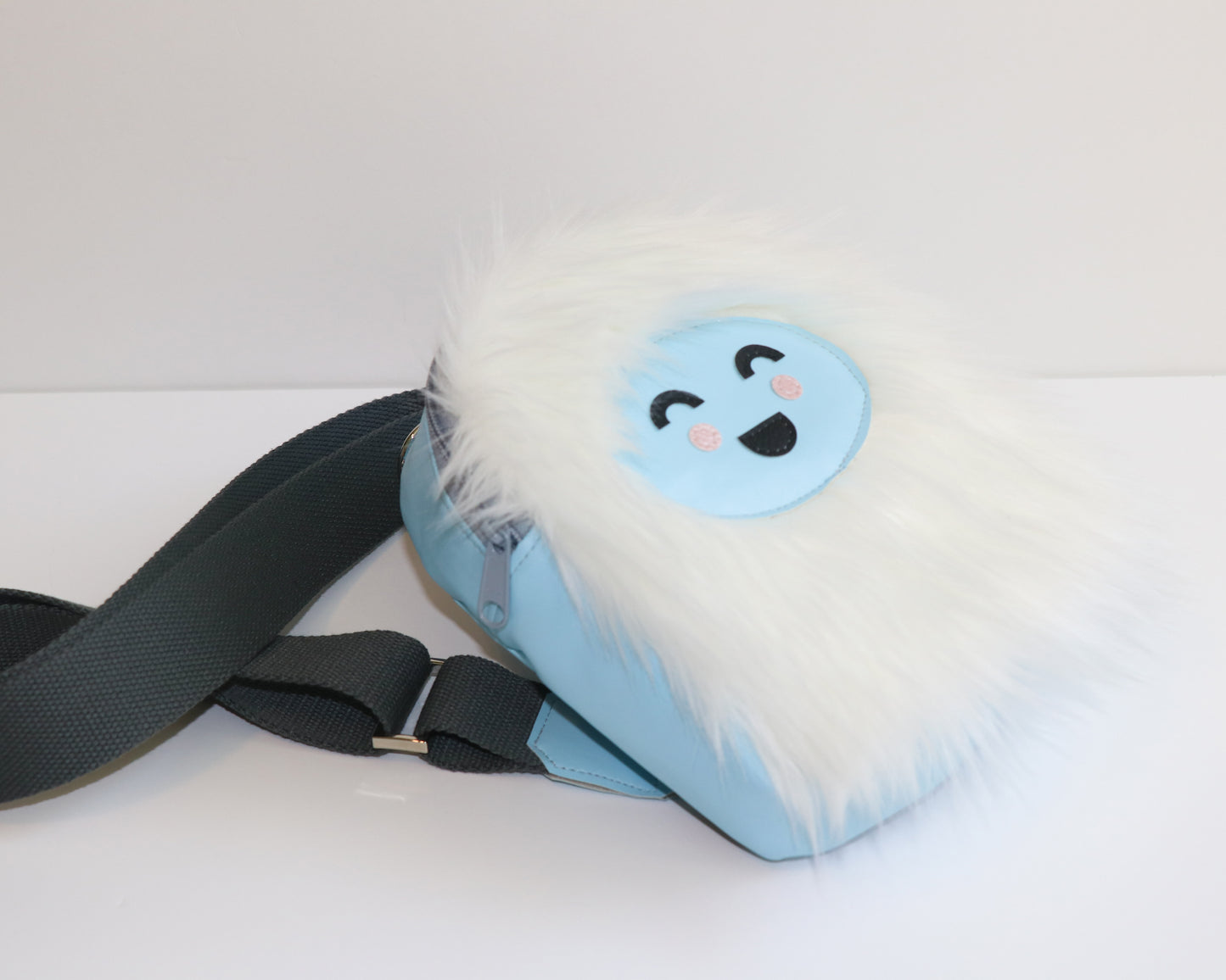 white furry Yeti mini backpack sling, side view