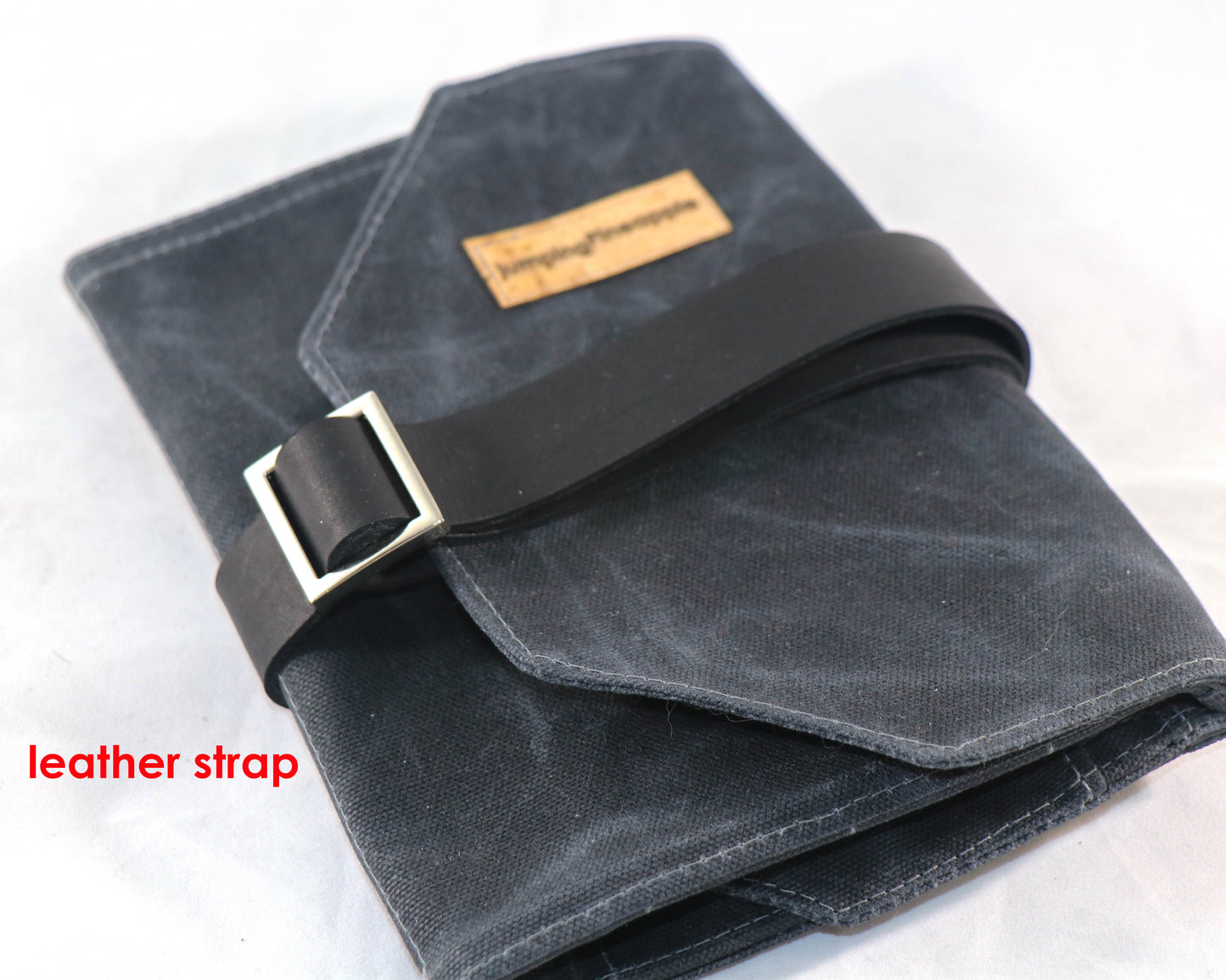 black waxed canvas artist roll, closed with leather strap