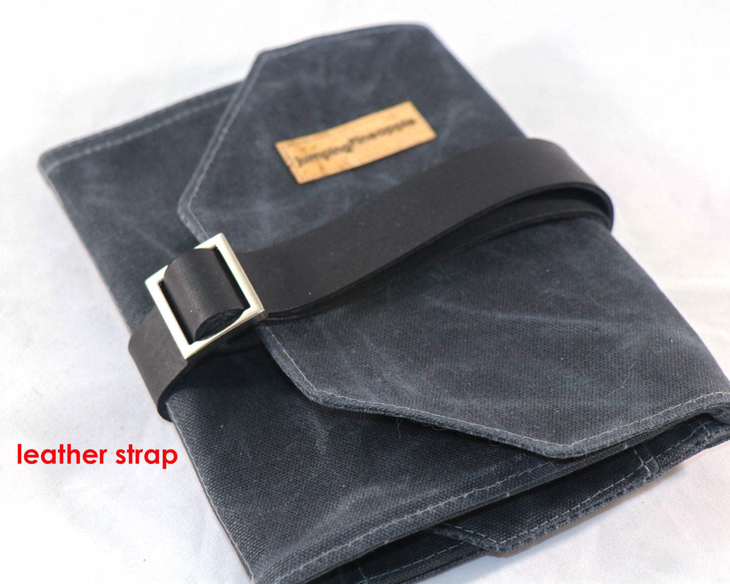 black waxed canvas artist roll, closed with leather strap