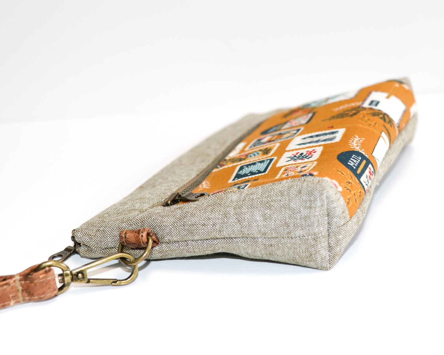 mustard postage stamps and olive linen wristlet laying flat