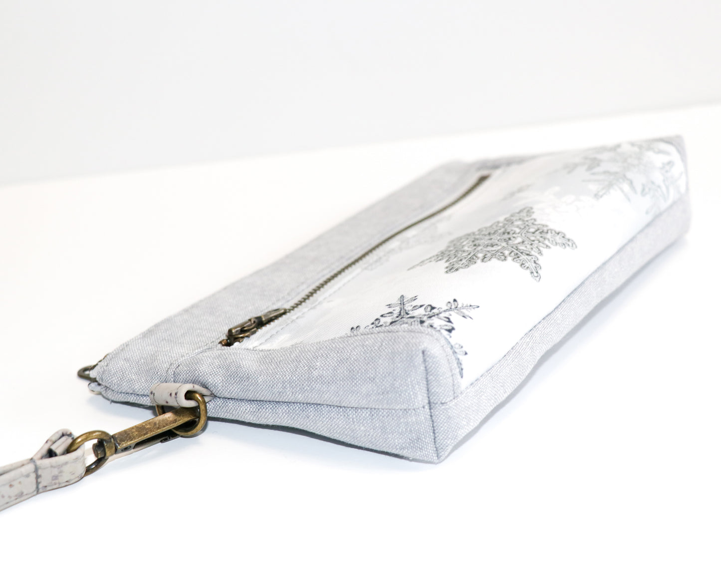 grey and metallic snowflake print wristlet laid flat