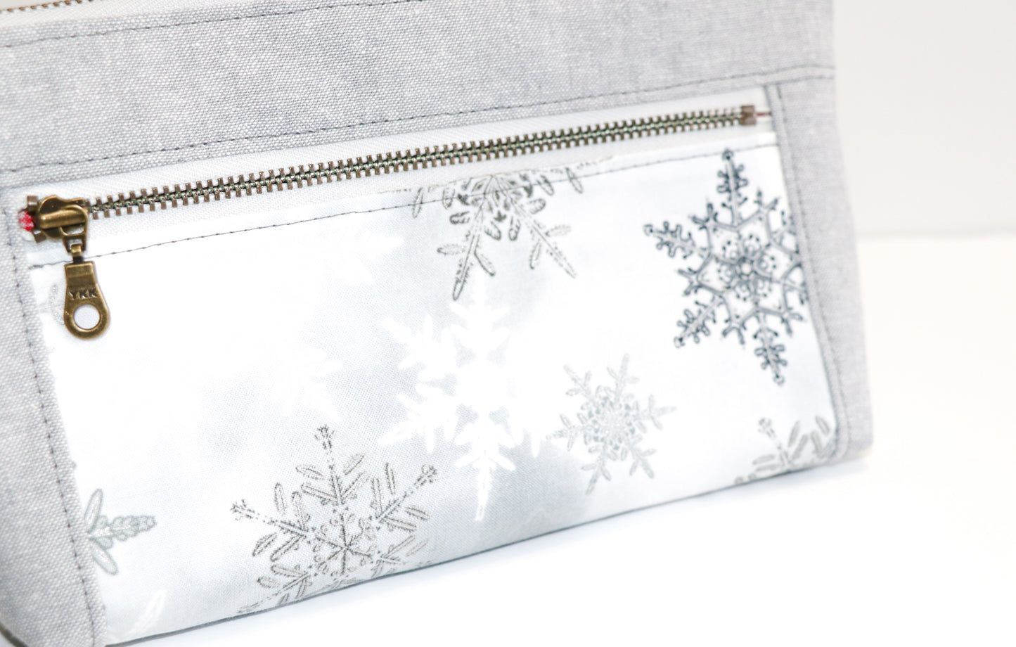grey and metallic snowflake print wristlet close up