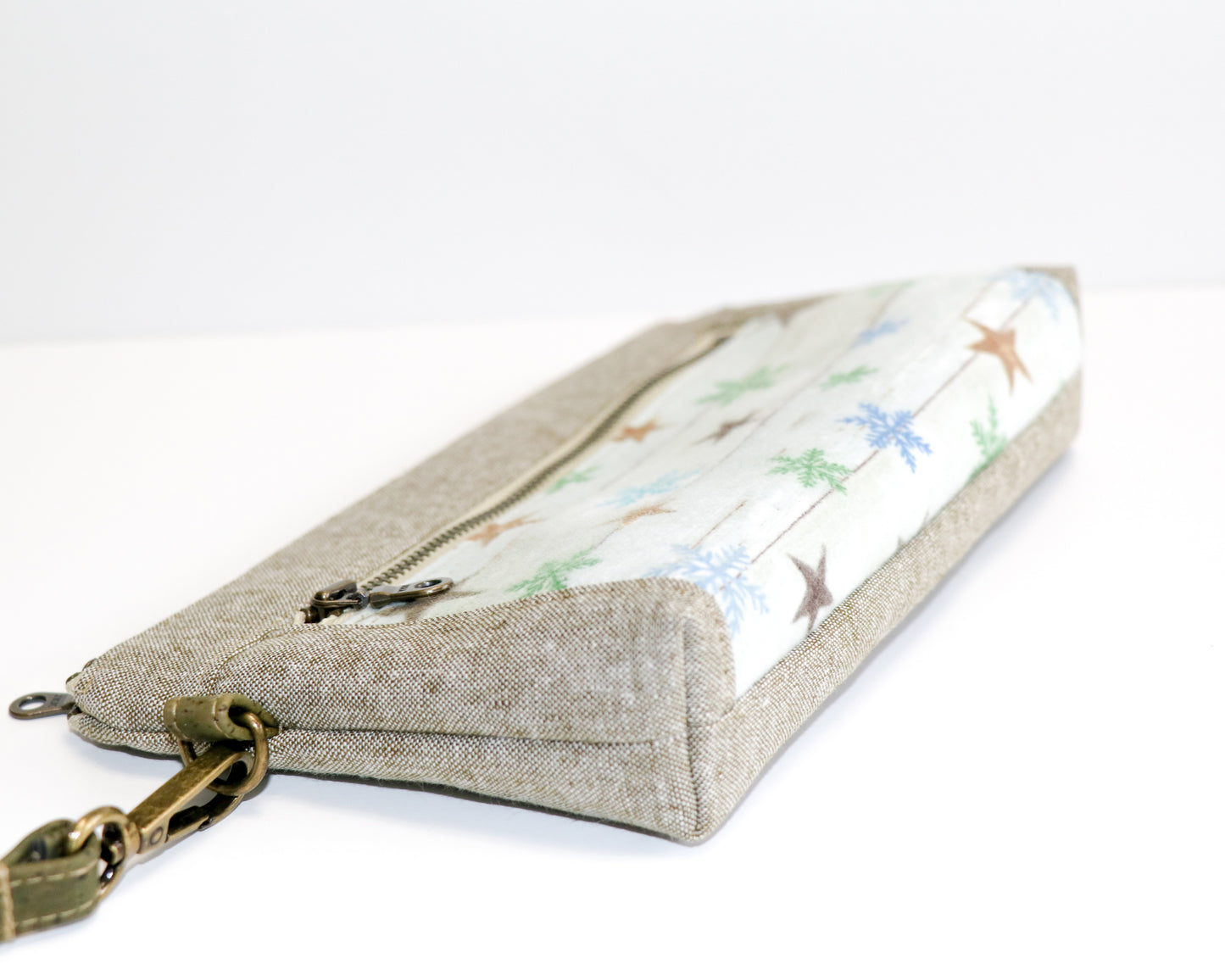 flannel stars and olive linen wristlet laid on side