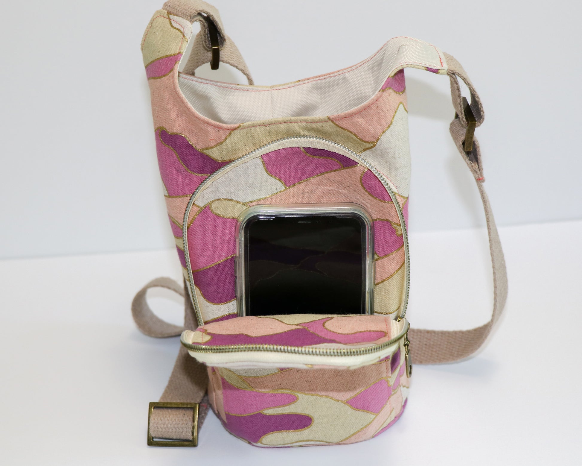 magenta and coral print water bottle sling, front view with pocket open showing phone inside