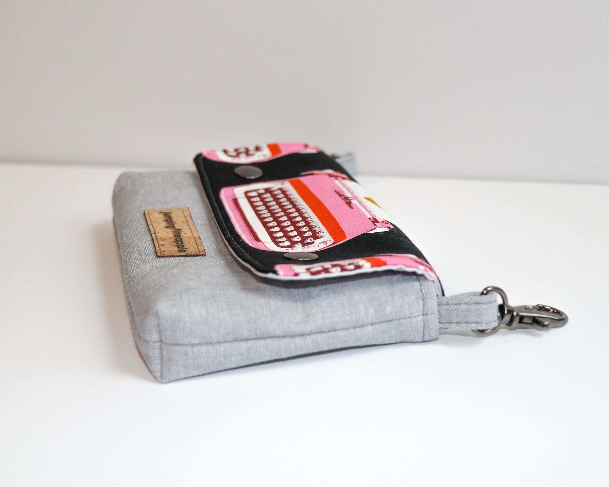 black and pink typewriter belt loop pouch, side view laying flat