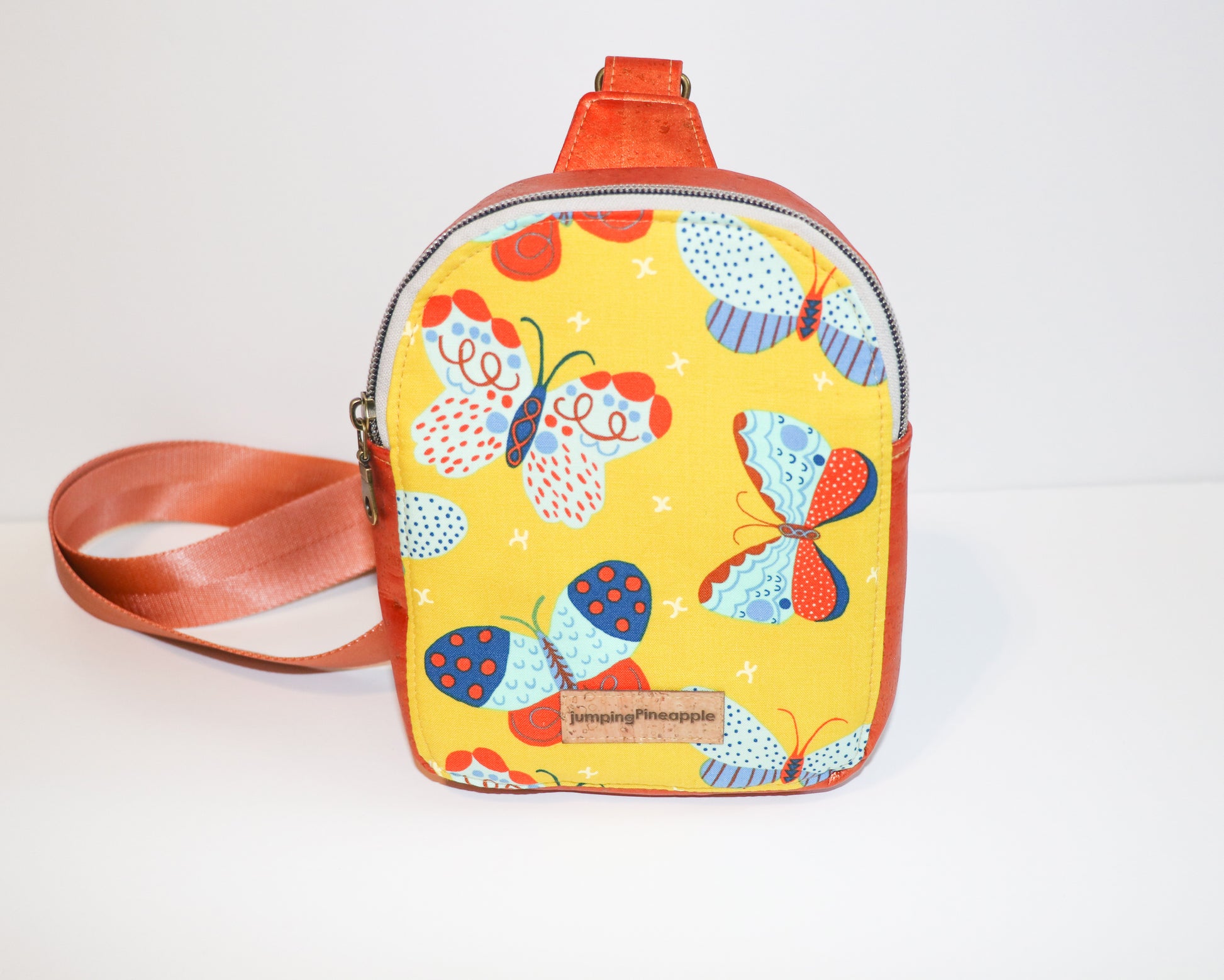 butterflies and shimmer orange cork mini backpack sling, front view
