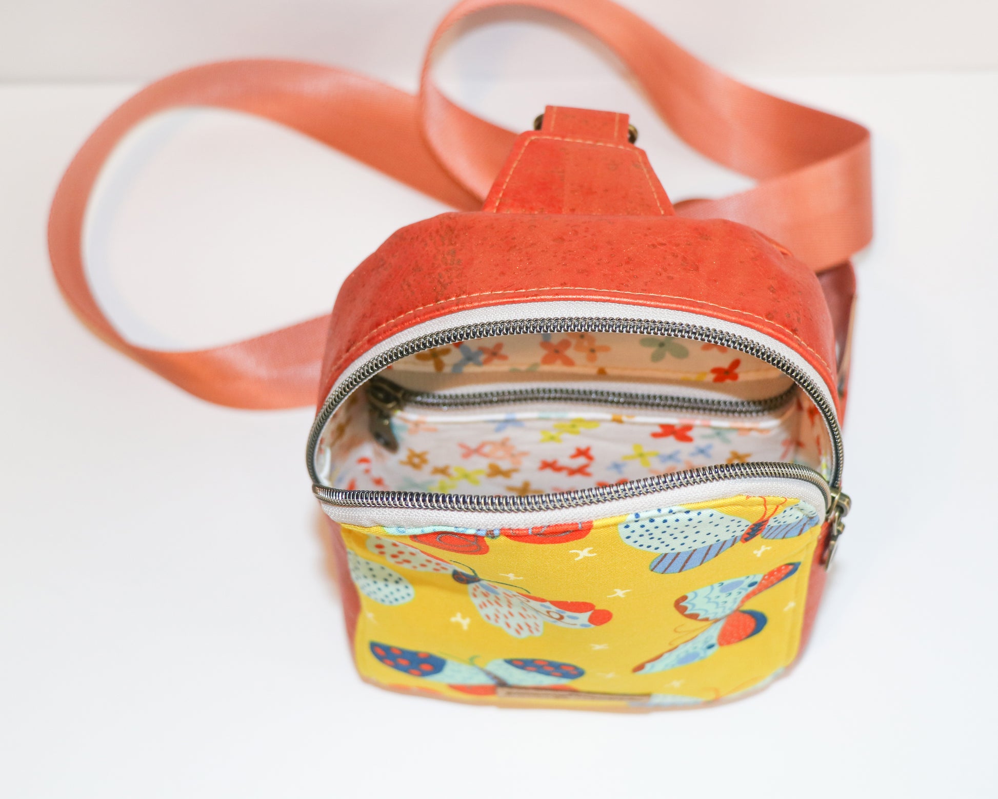 butterflies and shimmer orange cork mini backpack sling, inside/top view