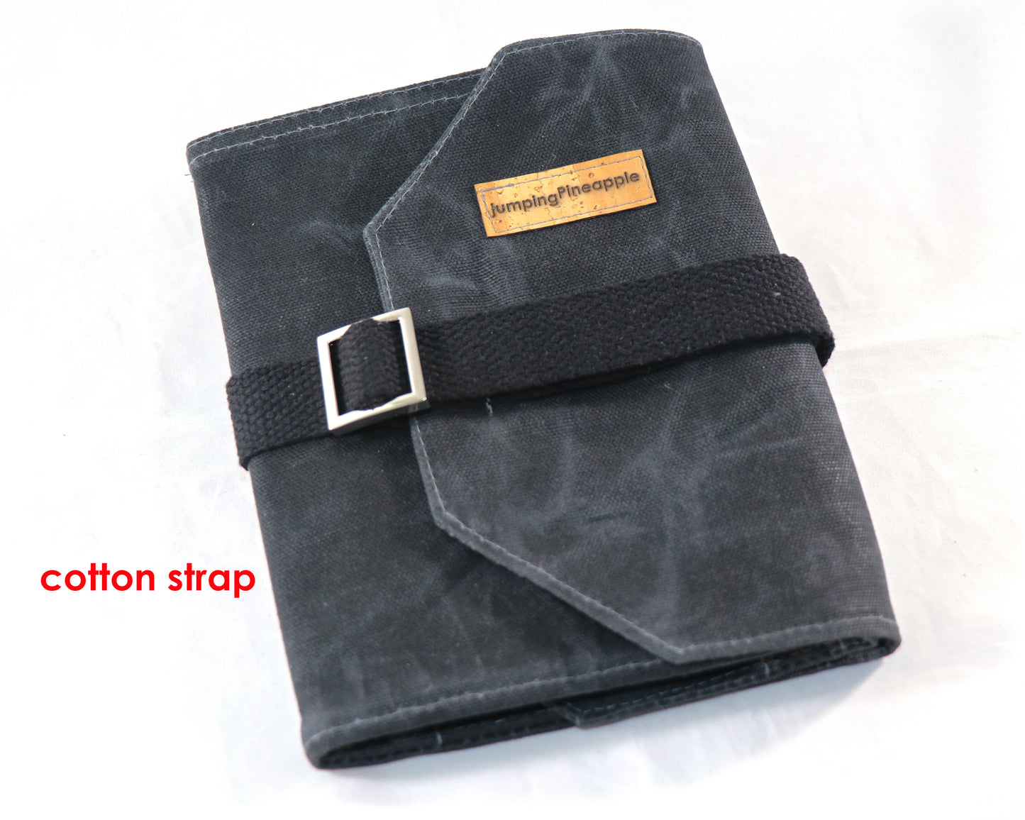 black waxed canvas artist roll, closed with cotton strap